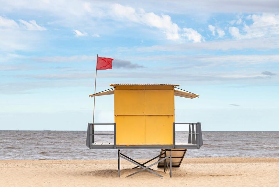 Et arkivfoto av en strand med rødt flagg, som indikerer badeforbud. Foto: Shutterstock