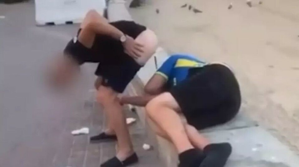 Her gjør turisten sitt fornødne på en sovende fotballsupporter på Mallorca. Saken har skapt raseri i sosiale medier.