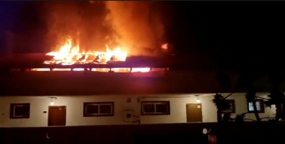 Flammene stod ut gjennom taket på bygningen tirsdag kveld. Foto: Policia Local