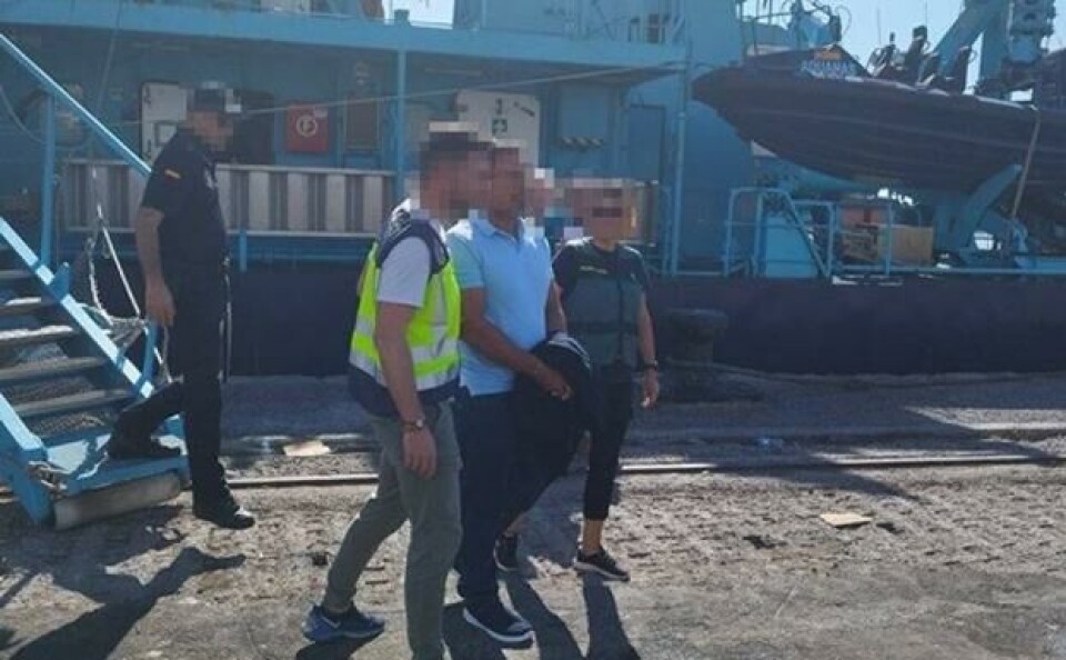 Her føres en av de pågrepne fra seilbåtene bort av politiet. Foto: Policia Nacional