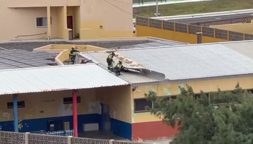 Arbeidere vurderer skaden på skoletaket.