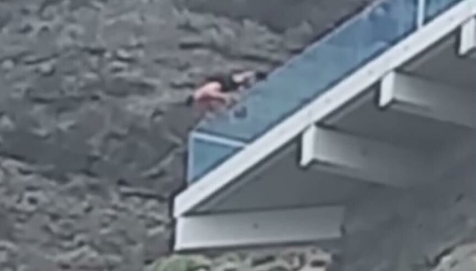 RISIKERER LIVET: Her står mannen på hendene ved kanten av utsiktspunktet.